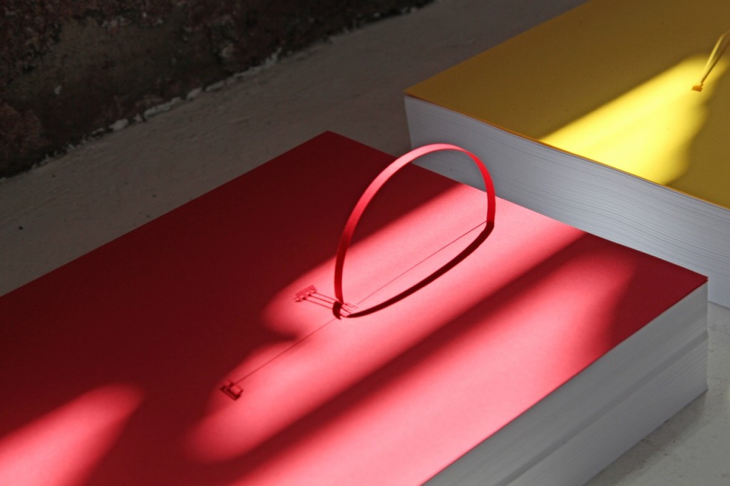 Marco Maggi, "Underline," 2014 (detail). Sixty 8 1/2 in. x 11 in. reams of paper; cuts and folds on 8 1/2 in. x 11in. sheets of yellow, blue, and red Wassau card-stock. Courtesy of Hosfelt Gallery.