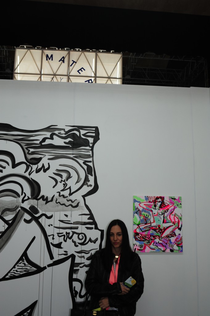 Mira Dancy infront of her work at Night Gallery, with the latin word for mother behind her.