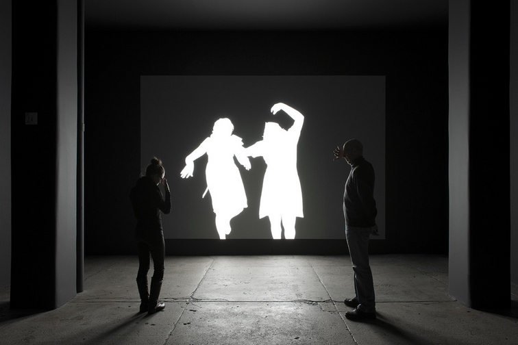 Alfredo Jaar. "Shadows." Installation View, installation with LED lights, aluminum, video projection, 116 x 174 inches. Original photograph by Koen Wessing (1942-2011): Estelí, Nicaragua, September 1978. Courtesy: Galerie Lelong, New York; © Netherlands Fotomuseum, Rotterdam, 2015.