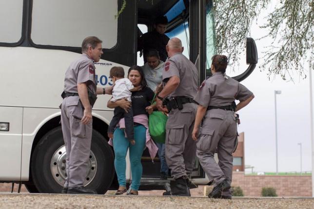 Migrants, consisting of mostly women and children, disembark from a U.S. Immigration and Customs Enforcement (ICE) bus at a Greyhound bus station in Phoenix, Arizona May 29, 2014. Photograph by Samantha Sais.