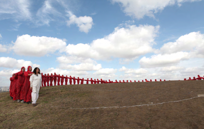 An Elongated Now, 2014. Documentation of performance for the Laguna Museum of Art, Art and Nature Festival. 300 performers dressed in white parallel the arc of Main Beach, Laguna over 3⁄4 of a mile. Laguna Beach, California. Photograph by Eric Minh Swenson. Courtesy of the artist and Kohn Gallery. 