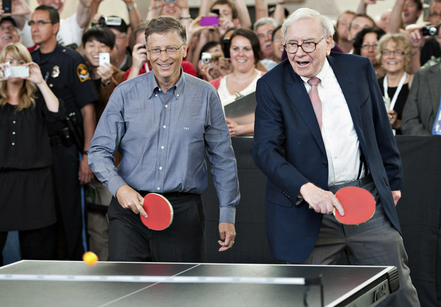 Warren Buffett and Bill Gates play table tennis Olympian Ariel Hsing during Berkshire Hathaway's annual shareholder meeting at Borsheims in Omaha, Nebraska on Sunday, May 6, 2012.