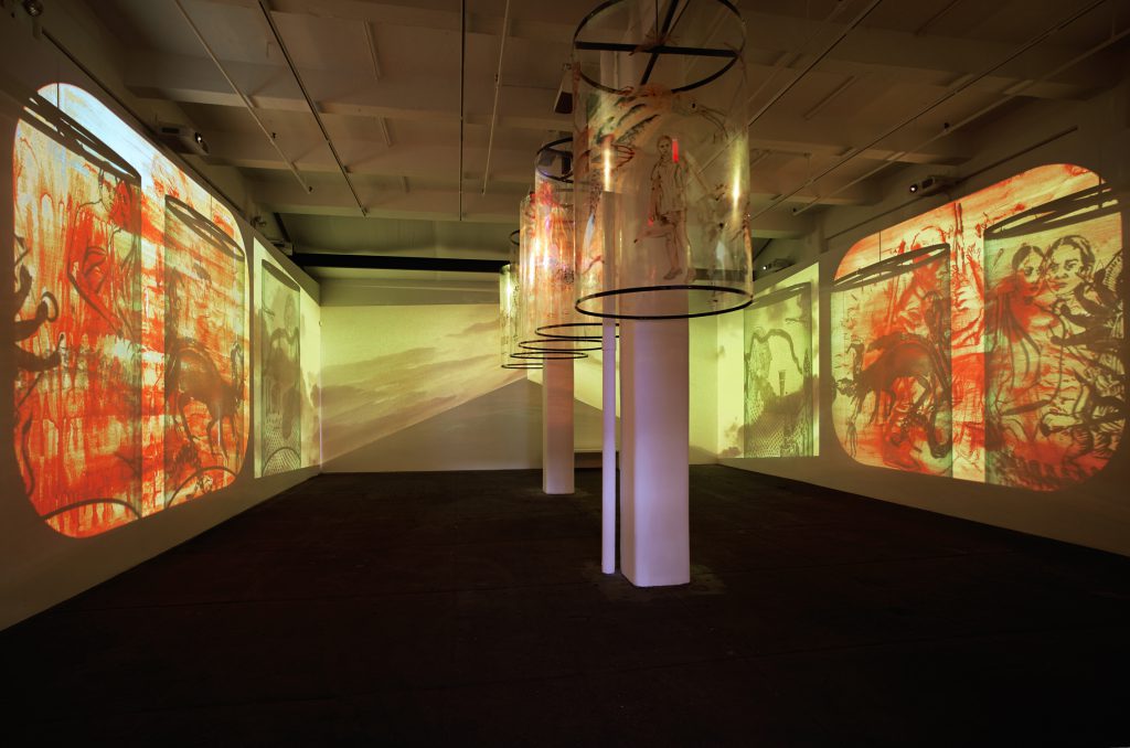 Nalini Malani, In Search of Vanished Blood, 2012, six-channel video (color, sound; 11:00 minutes) and five Mylar cylinders.  Installation view, Nalini Malani: In Search of Vanished Blood, Galerie Lelong, New York, 2013. Courtesy Galerie Lelong, New York and Paris. © 2016 Nalini Malani