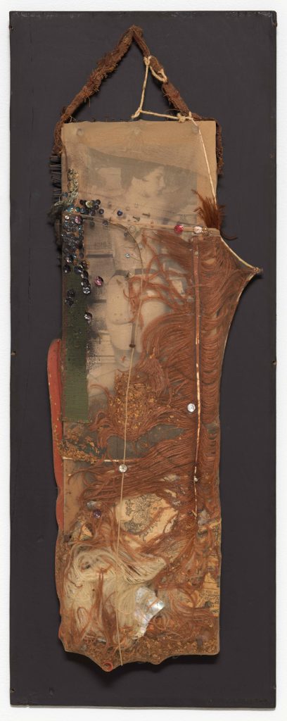 BLACK DAHLIA, 1960; cut and pasted printed papers, feather, fabric, rubber tubing, razor blade, nails, tobacco, sequins, string, shell, and paint encased in nylon stocking over wood; 26 3/4 × 10 3/4 × 2 3/4 in. (68 × 27.3 × 7 cm); the Museum of Modern Art, New York, purchase; © 2016 Conner Family Trust, San Francisco / Artists Rights Society (ARS), New York